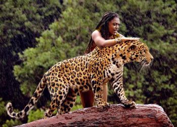 a woman standing on a log with a jaguar - Ai generated