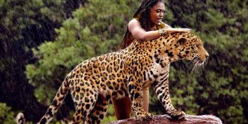 a woman standing on a log with a jaguar - Ai generated